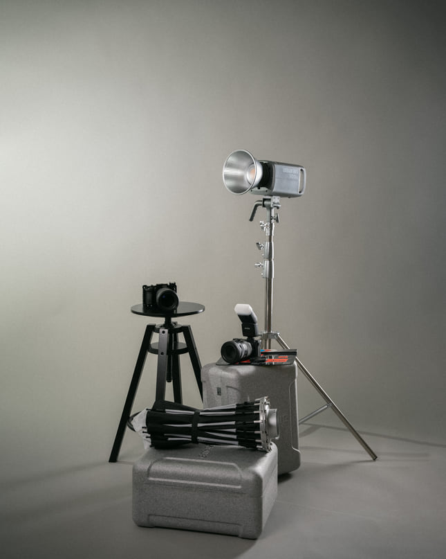 Equipo de estudio: cámara sobre silla, luz profesional y trípode.